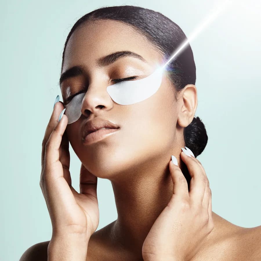A woman enjoying a quiet skincare moment with under-eye patches