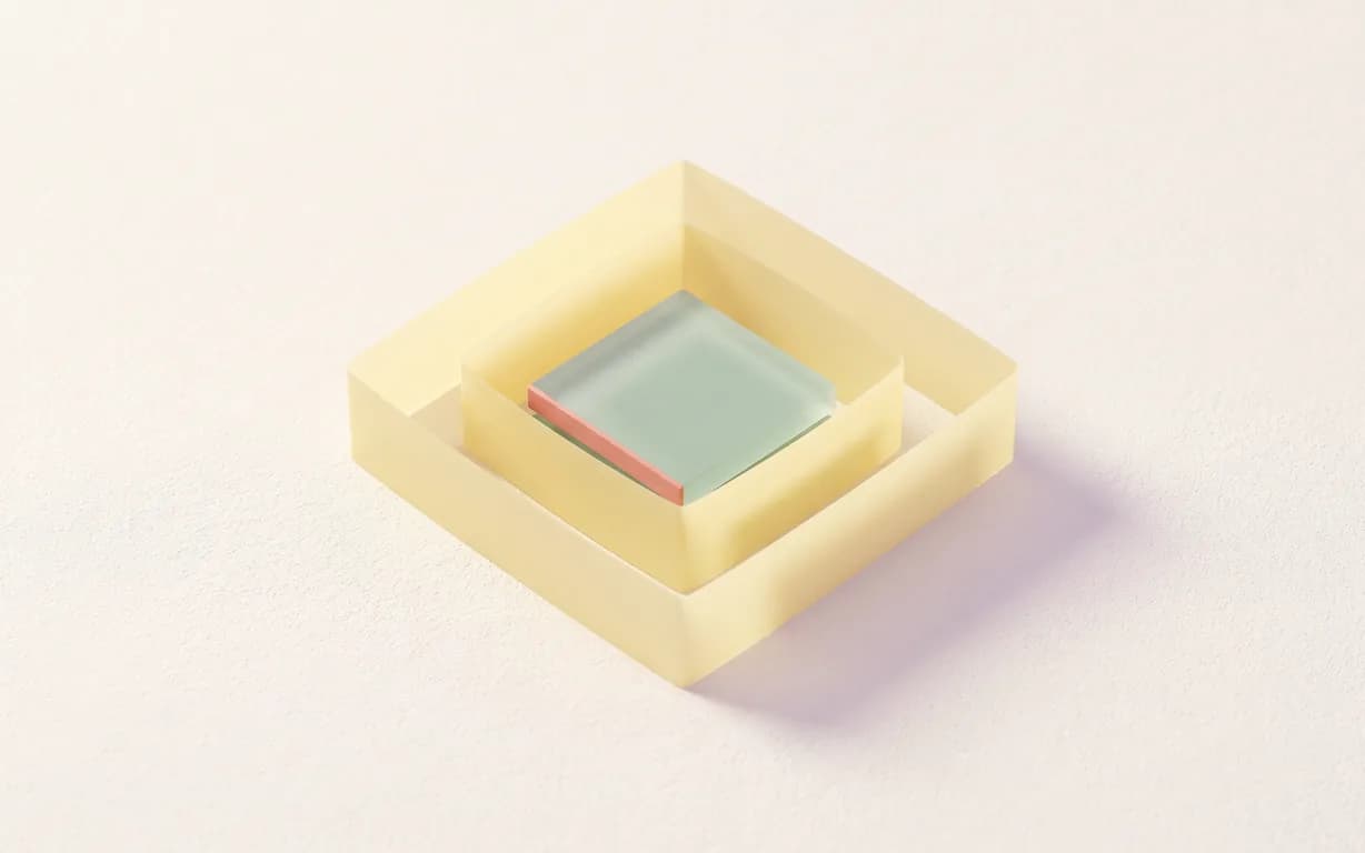 A translucent butter-yellow strip folds into a squared channel around a celadon glass tile on warm ivory plaster, with a narrow coral inner edge.