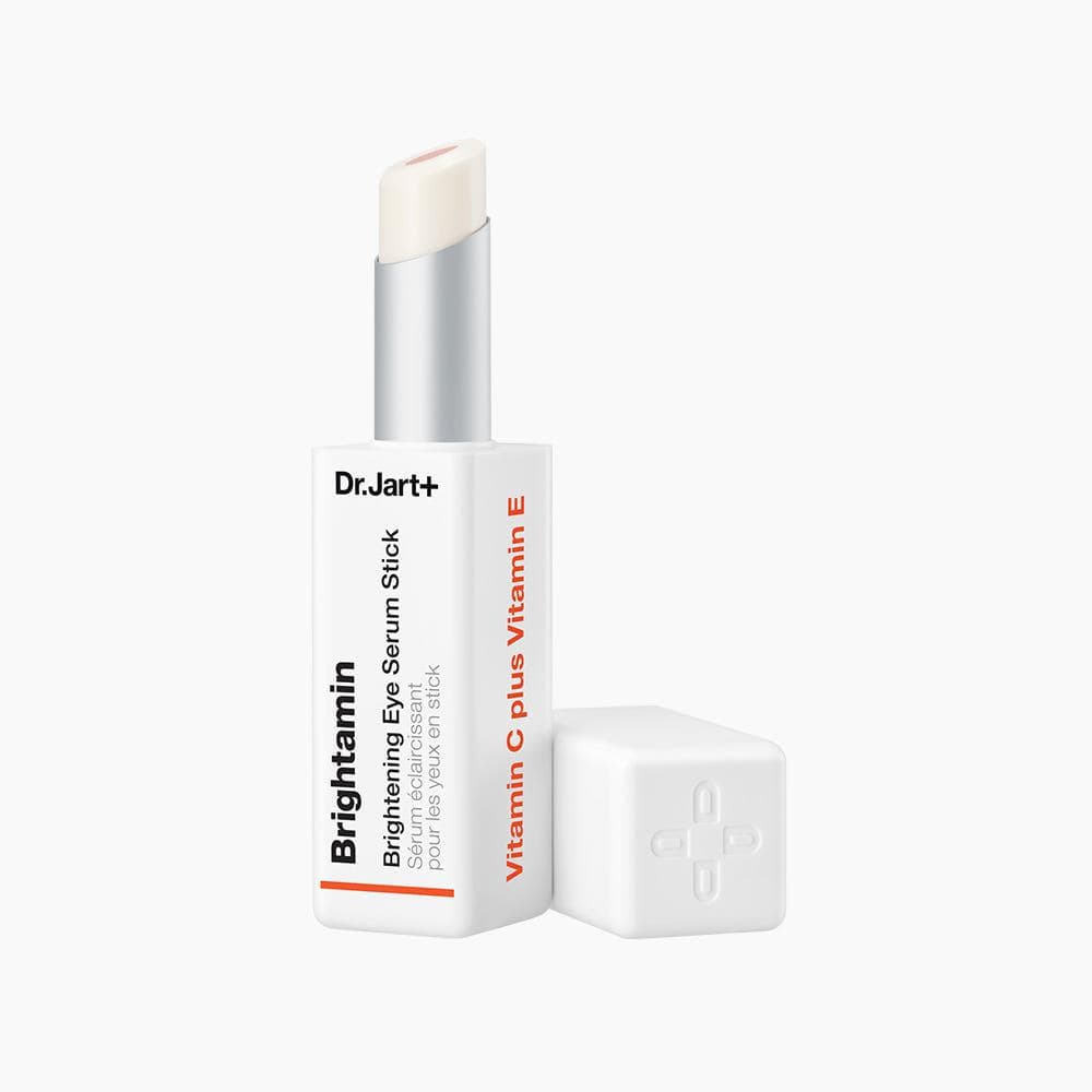 White rectangular serum stick with pale orange balm exposed, standing beside its square cap on a white background.