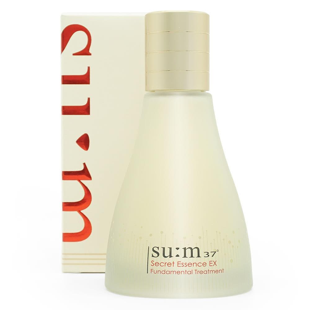 Frosted ivory Su:m37 Secret Essence EX bottle with a ribbed gold cap in front of its cream carton with red su:m lettering, on a white background.